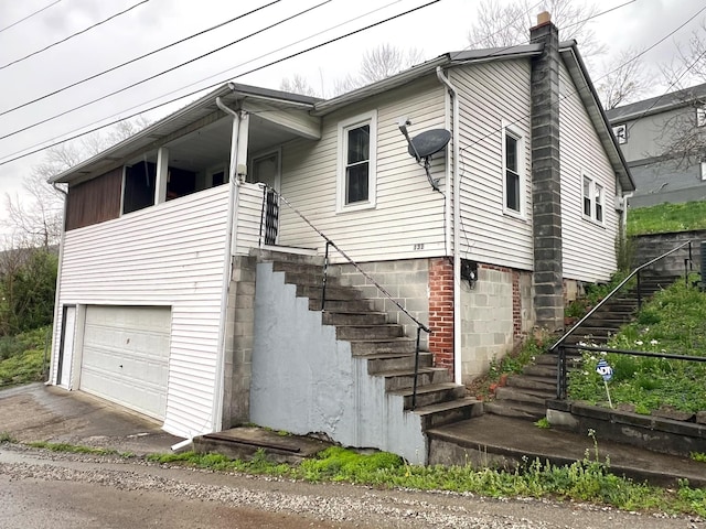 131 Keller St, Cumberland, KY 40823 - view of front facade with an attached garage, a chimney, driveway, and stairway