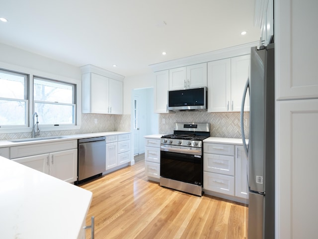 748 Wellington Way, Lexington, KY 40503 - kitchen featuring stainless steel appliances, tasteful backsplash, white cabinetry, and a sink