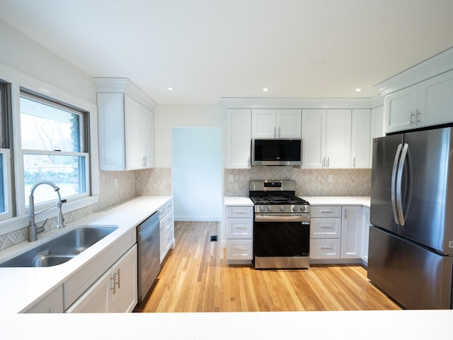748 Wellington Way, Lexington, KY 40503 - kitchen with light countertops, white cabinets, light wood-style floors, appliances with stainless steel finishes, and a sink
