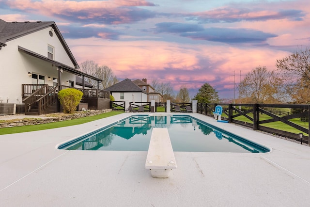 211 Eric Dr, Richmond, KY 40475 - pool at dusk featuring a diving board, fence, a patio, a fenced in pool, and stairs