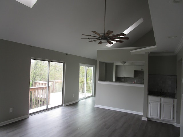 unfurnished living room with a ceiling fan, baseboards, crown molding, and dark wood-style floors