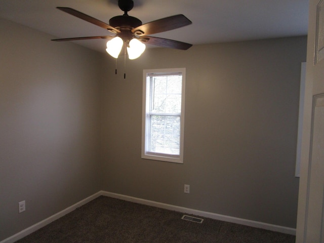 unfurnished room with dark carpet, ceiling fan, baseboards, and visible vents