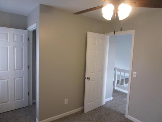 unfurnished bedroom with ceiling fan, carpet flooring, and baseboards