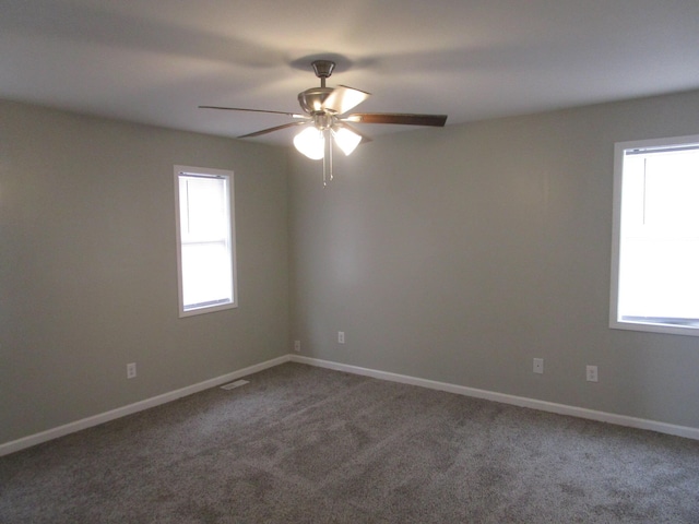 empty room with ceiling fan, carpet floors, baseboards, and a healthy amount of sunlight