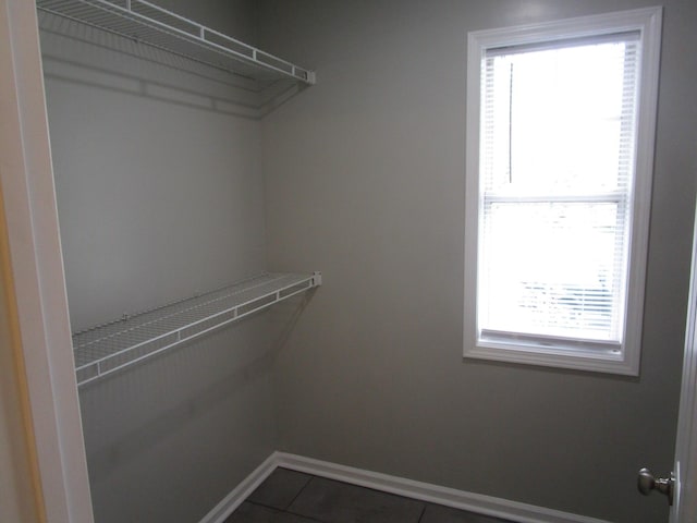 spacious closet featuring dark tile patterned flooring