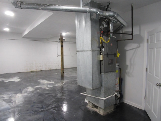 finished below grade area featuring heating unit and concrete block wall