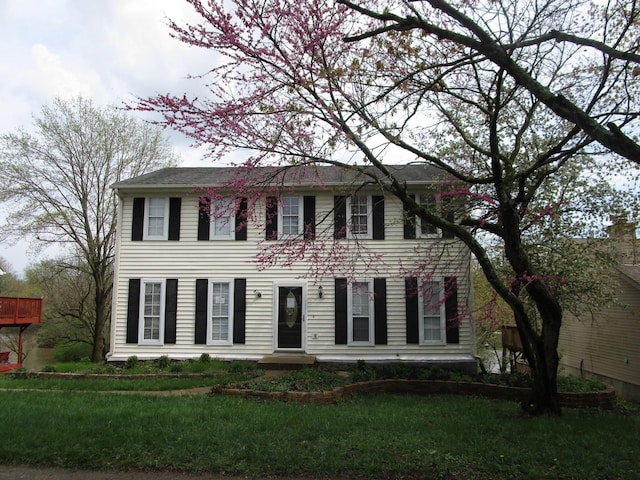 colonial house featuring a front lawn