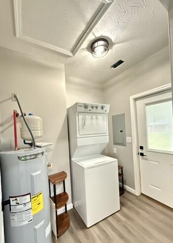 1476 Gosser Ridge Rd, Liberty, KY 42539 - laundry room with stacked washer and clothes dryer, water heater, electric panel, and light wood finished floors
