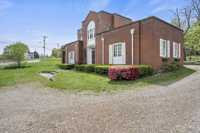 view of side of home featuring a lawn and brick siding