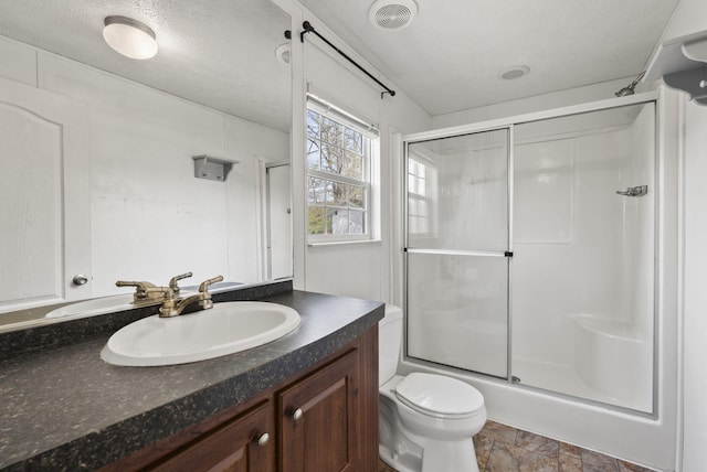 bathroom with visible vents, stone finish flooring, vanity, and toilet