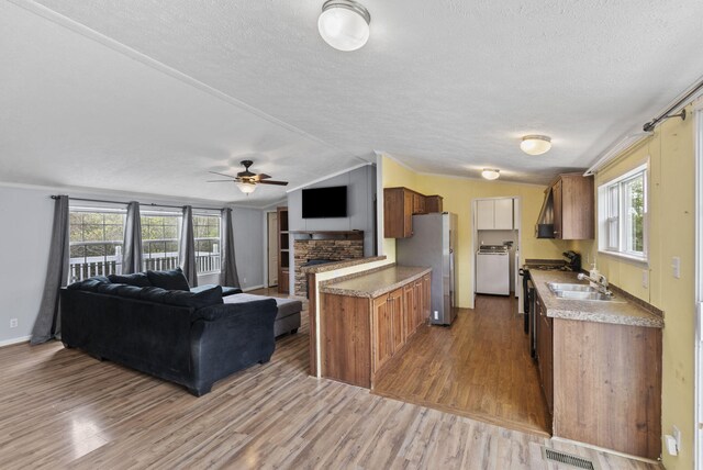 kitchen with washer / dryer, open floor plan, visible vents, and freestanding refrigerator