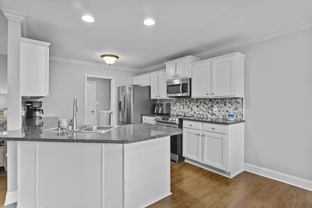 kitchen featuring appliances with stainless steel finishes, a sink, white cabinets, dark wood-type flooring, and crown molding