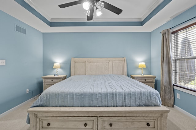 bedroom featuring light colored carpet, crown molding, multiple windows, baseboards, and a raised ceiling