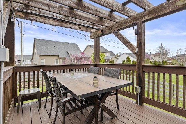 wooden terrace with a residential view, outdoor dining space, and a pergola
