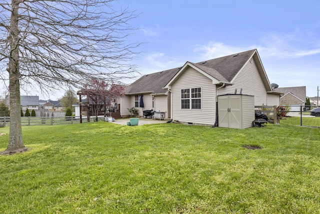back of property with a patio, a shingled roof, an outdoor structure, and a storage shed