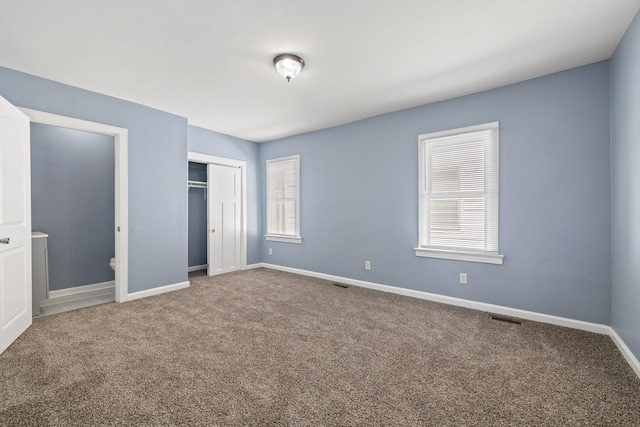 unfurnished bedroom with carpet floors, baseboards, a closet, and visible vents