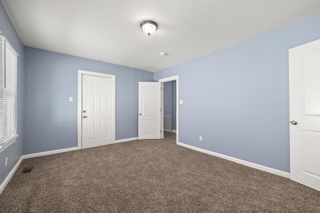 unfurnished bedroom with carpet flooring, baseboards, and visible vents