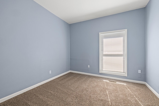 carpeted spare room with baseboards