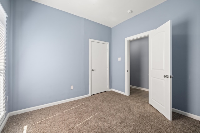 unfurnished bedroom with carpet and baseboards