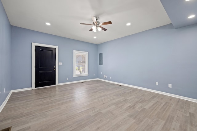 spare room with baseboards, electric panel, recessed lighting, light wood-style flooring, and ceiling fan