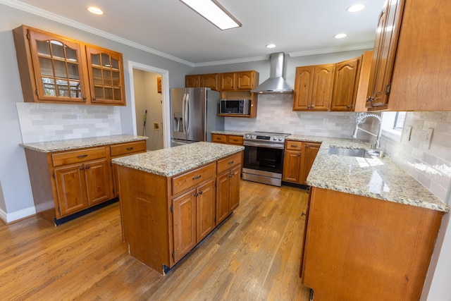 kitchen featuring light wood-style flooring, a sink, wall chimney exhaust hood, and stainless steel appliances