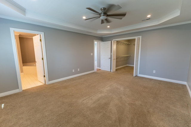 unfurnished bedroom featuring baseboards, carpet floors, crown molding, and a raised ceiling
