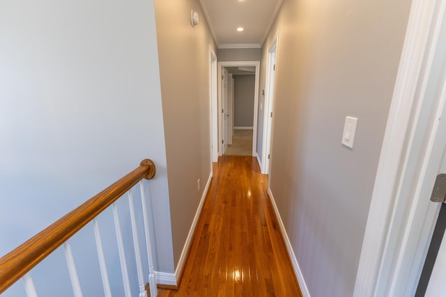 hall featuring baseboards, ornamental molding, recessed lighting, an upstairs landing, and wood finished floors