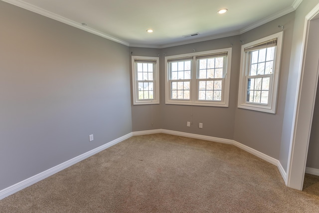 empty room featuring a healthy amount of sunlight, light colored carpet, and visible vents