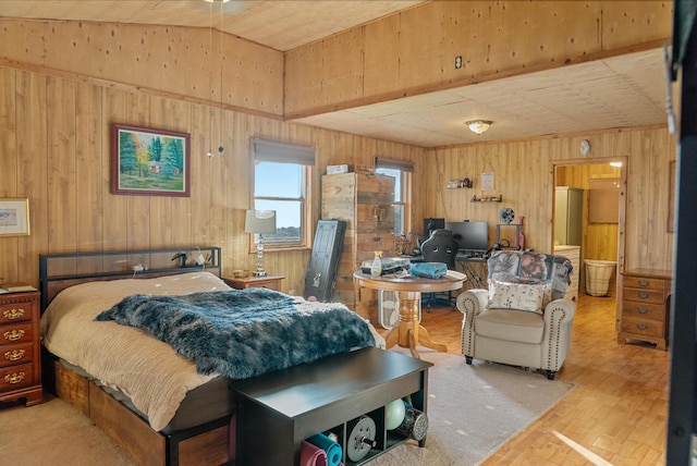 bedroom with wood walls, wood finished floors, and lofted ceiling