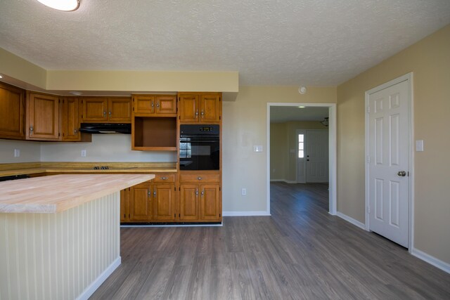 186 Main St, Sharpsburg, KY 40374 - kitchen with oven, dark wood-style floors, brown cabinets, wood counters, and under cabinet range hood