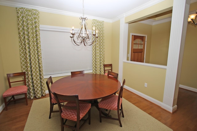 dining room with ornamental molding, baseboards, a chandelier, and wood finished floors