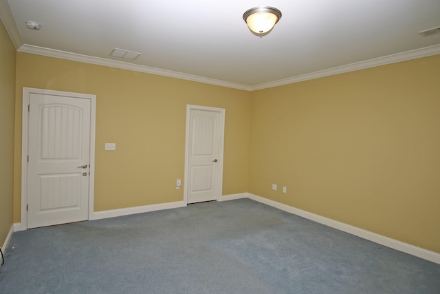spare room with visible vents, baseboards, ornamental molding, and carpet