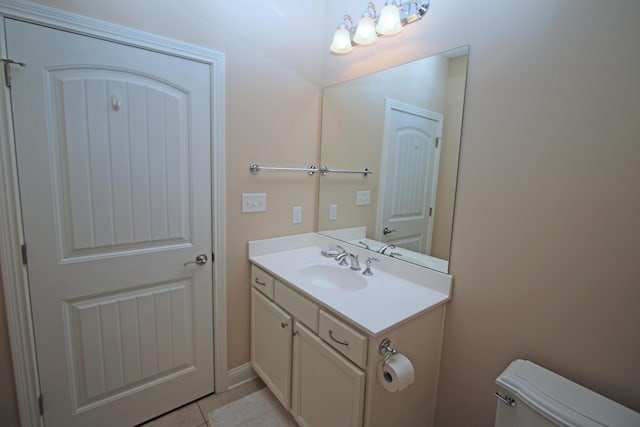 bathroom with toilet, tile patterned floors, and vanity