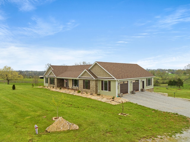 single story home featuring a garage, gravel driveway, a shingled roof, and a front yard