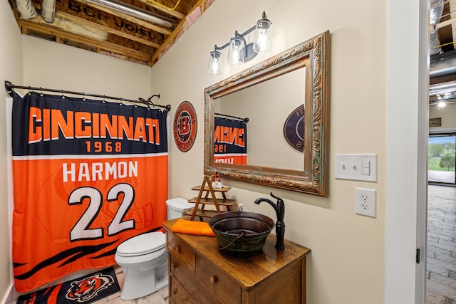 bathroom with curtained shower, vanity, and toilet