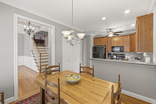 dining room with ornamental molding, stairs, recessed lighting, light wood-style flooring, and ceiling fan with notable chandelier