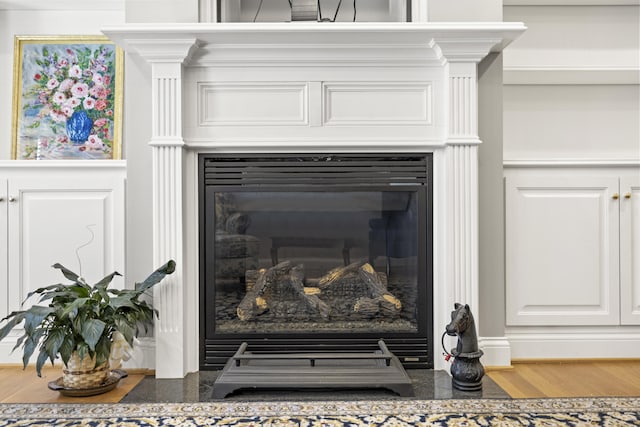 room details with a fireplace with flush hearth and wood finished floors