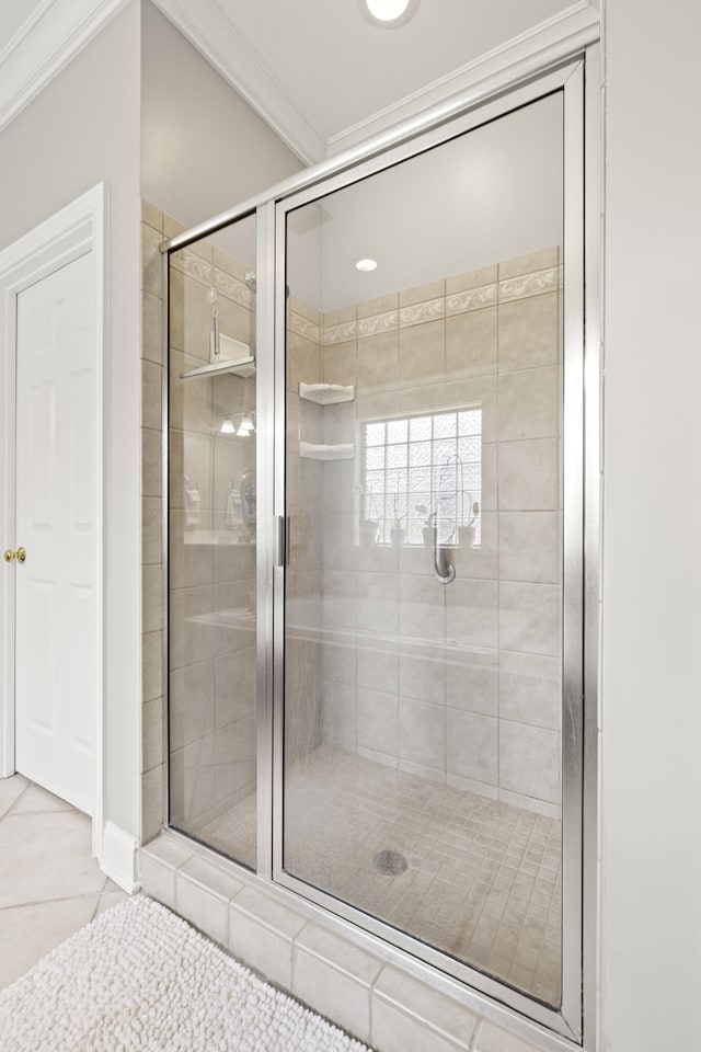 full bath with tile patterned flooring, ornamental molding, and a shower stall