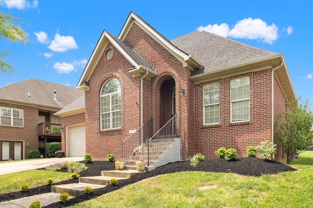 traditional-style house featuring brick siding, a shingled roof, a front lawn, and an attached garage