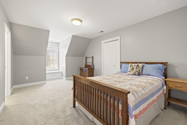 carpeted bedroom featuring visible vents, baseboards, vaulted ceiling, and a closet