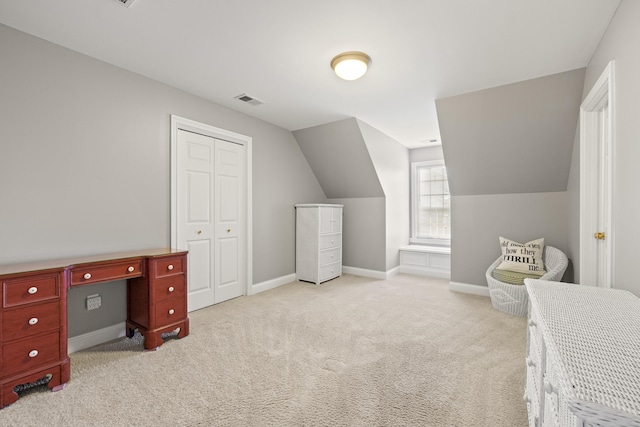 carpeted bedroom with baseboards, visible vents, lofted ceiling, and a closet