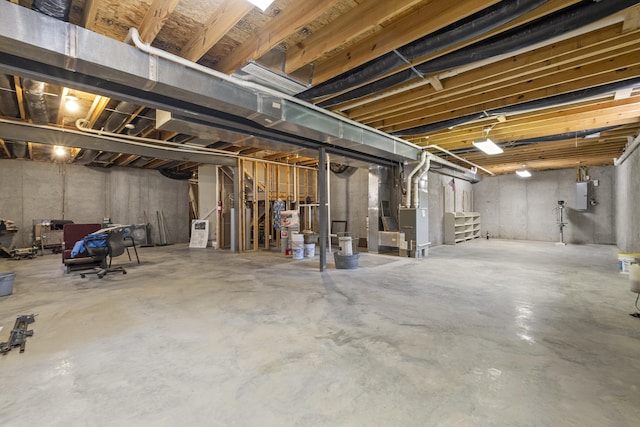 unfinished below grade area with stairway, heating unit, and electric panel