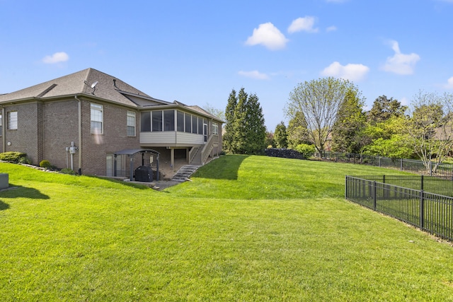 view of yard with a fenced backyard, stairs, and a sunroom