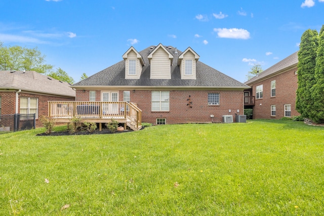 back of property featuring a yard, a deck, and brick siding