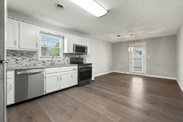1124 Heartland Dr, Somerset, KY 42503 - kitchen featuring appliances with stainless steel finishes, white cabinetry, dark wood-type flooring, decorative backsplash, and a sink