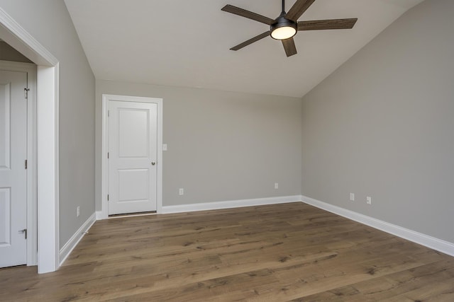 spare room featuring baseboards, vaulted ceiling, a ceiling fan, and wood finished floors