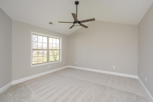 carpeted empty room featuring baseboards, lofted ceiling, a ceiling fan, and visible vents