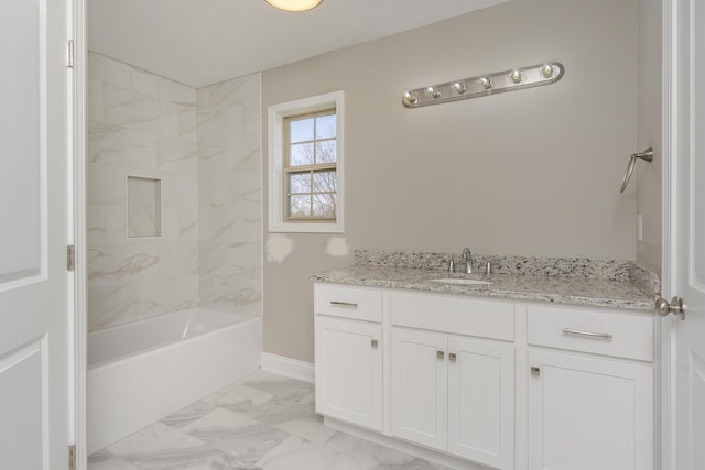 bathroom featuring marble finish floor, vanity, and bathing tub / shower combination