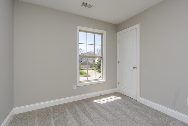 empty room with baseboards, visible vents, and carpet floors