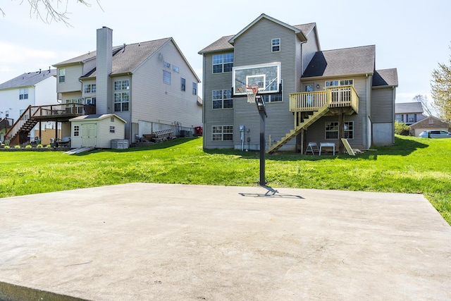 back of property with stairs, central AC, a wooden deck, and a lawn